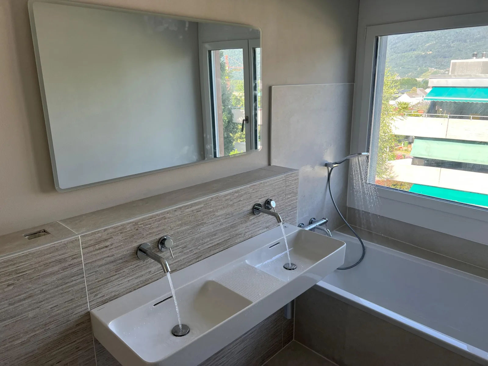 Sanierte Badezimmer mit Doppelwaschtisch, Wandarmaturen und Badewanne in Biel