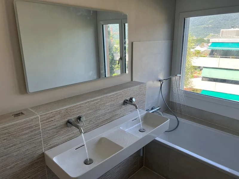 Sanierte Badezimmer mit Doppelwaschtisch, Wandarmaturen und Badewanne in Biel
