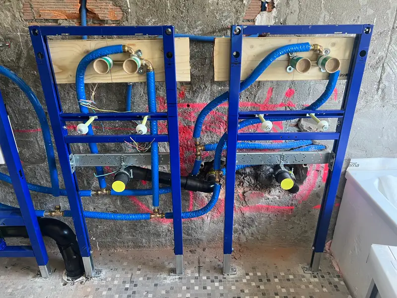 Sanitär-Vorwandinstallation mit Wasserleitungen und Abläufen vor dem Beplanken