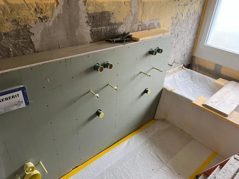 Beplankte Vorwand mit vorbereiteten Anschlüssen für WC, Waschtisch und Armaturen